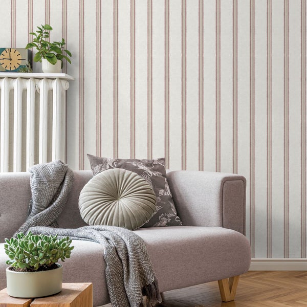 Wohnzimmer mit gestreifter Tapete, Sofa, Kissen und Zimmerpflanzen