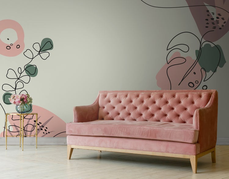 Modernes Wohnzimmer mit Samtsofa mit Knopfheftung vor einer Wand mit abstrakter floraler Fototapete und einem Beistelltisch.
