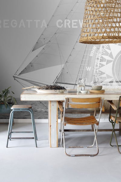 Esszimmer mit Holztisch, Stühlen und Segelschiff-Tapete für maritimes Flair