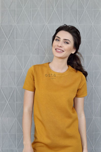 Frau mit gelbem T-Shirt mit "esta home" Aufdruck