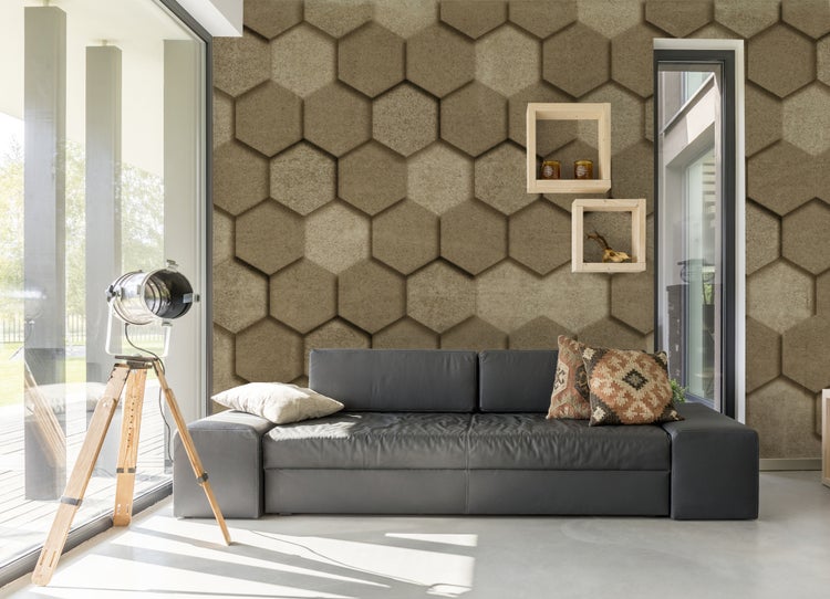 Fototapete mit dreidimensionalem Sechseck-Muster in Steinoptik in einem modernen Wohnzimmer mit grauem Sofa und Stativlampe.