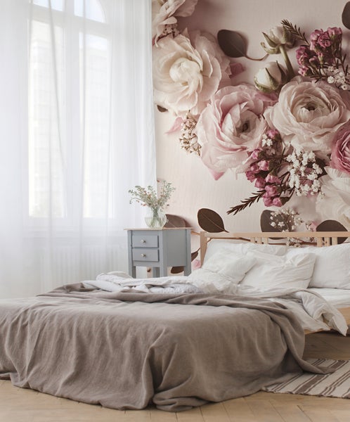 Helles Schlafzimmer mit großflächiger Fototapete mit Rosenmotiven, Holzbett, grauem Nachttisch und weißen Vorhängen.