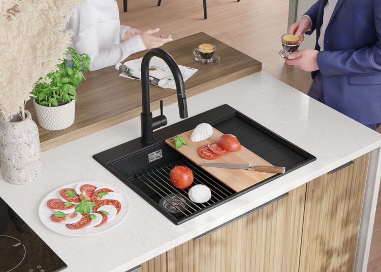 Küchenszene mit Spüle, Armatur und Lebensmitteln auf einer Arbeitsplatte.