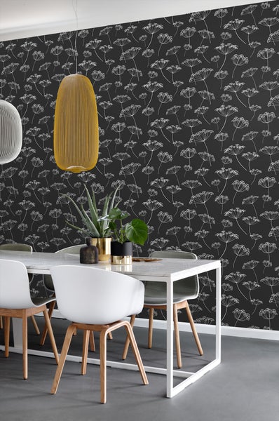 Esstisch mit Stühlen vor einer Wand mit Blumenmuster-Tapete und Pendelleuchten