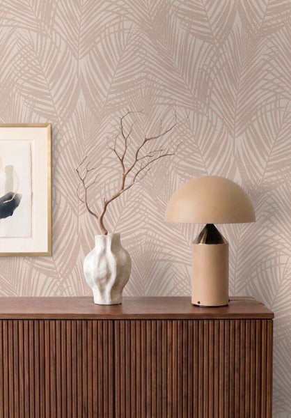 Tapete mit tropischem Palmenblatt Muster in einem modern eingerichteten Raum mit Holzkommode und Lampe.