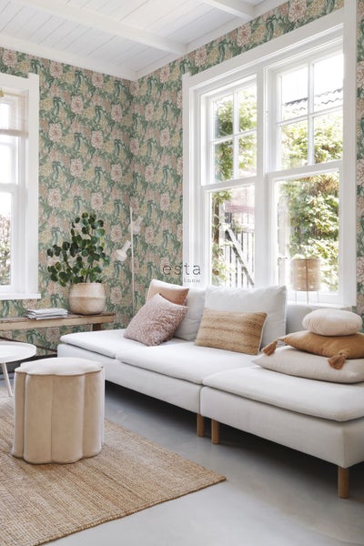 Heller Wohnraum mit floraler Tapete, Sofa, Kissen und Teppich