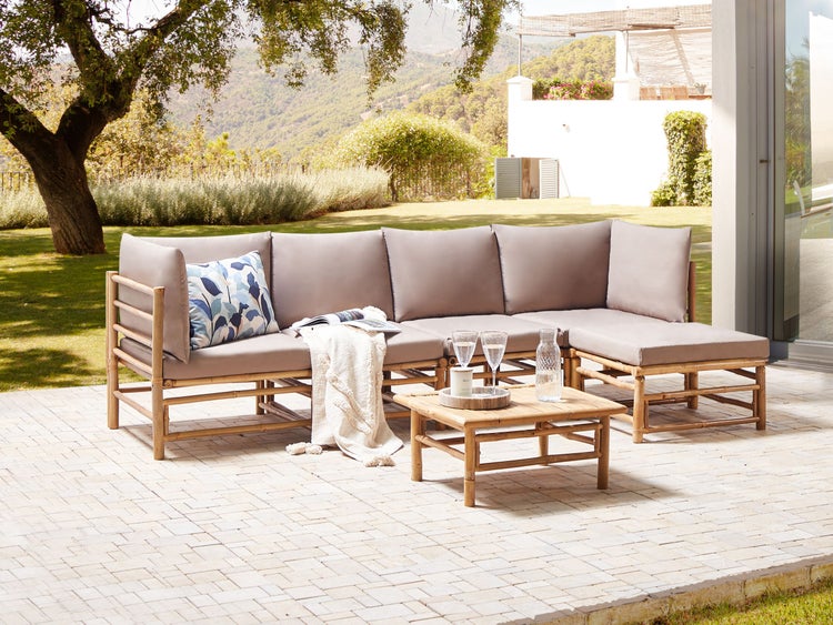 Gartenszene mit Bambus-Lounge-Set und Couchtisch auf einer Terrasse
