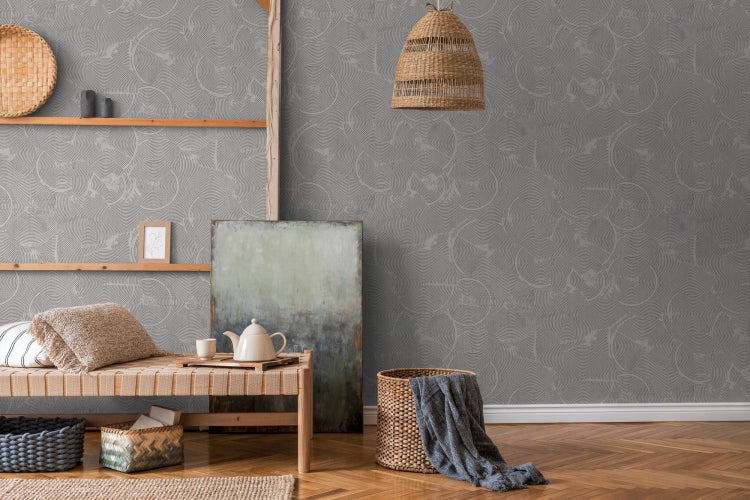 Wohnzimmer mit Rattansessel, Holztisch, Dekoration und gemusterter Tapete für ein gemütliches Ambiente.