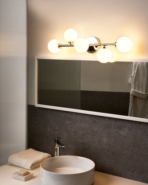 Modernes Badezimmer mit Waschtisch, Spiegel und Wandleuchte
