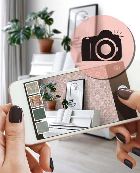 Raumansicht mit gemusterter Tapete, Sessel, Kissen und dekorativen Vasen