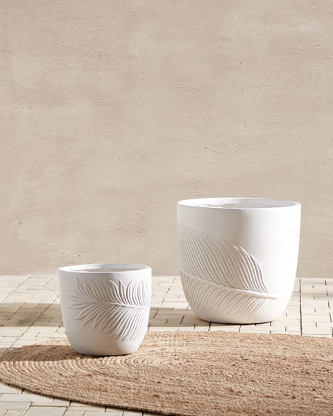 Zwei weiße Pflanzgefäße mit Blattmuster auf dem Außendesign
