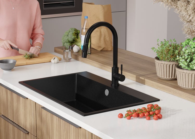 Schwarze Küchenspüle mit Armatur in einer hellen Küche