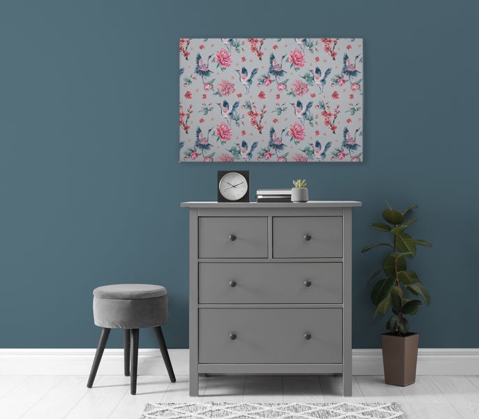 Wandbild mit Kranich und Blumenmuster über einer grauen Kommode mit Hocker und Pflanze in einem modern eingerichteten Wohnraum
