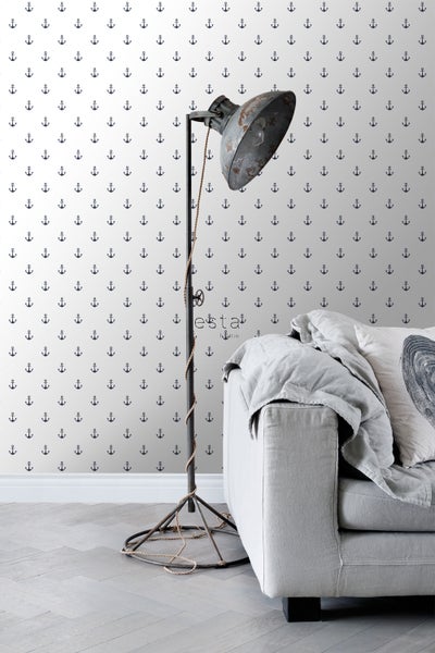 Innenaufnahme eines Raumes mit Anker-Tapete, Stehlampe und Sofa.