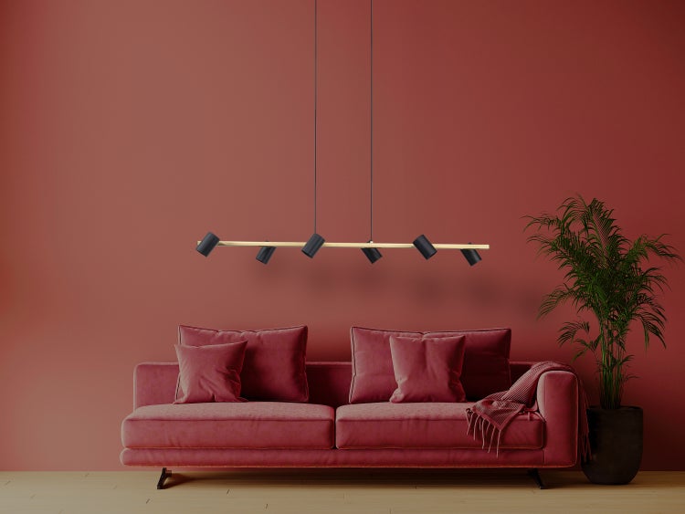 Modernes Wohnzimmer mit Sofa, Zimmerpflanze und Hängelampe.