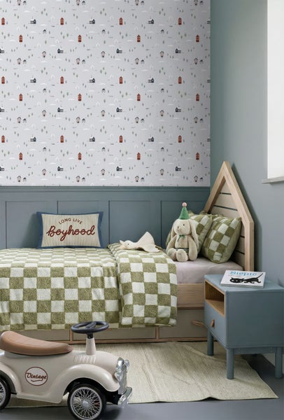 Kinderzimmer mit Mustertapete, Holzhaus-Bett, karierter Bettwäsche und kleinem Nachttisch.