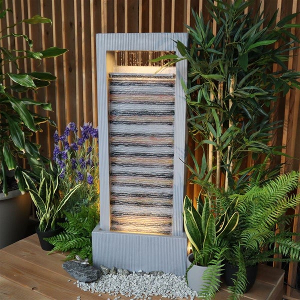 Dekorativer Zimmerbrunnen mit Steinoptik und Pflanzenarrangements für eine entspannende Atmosphäre