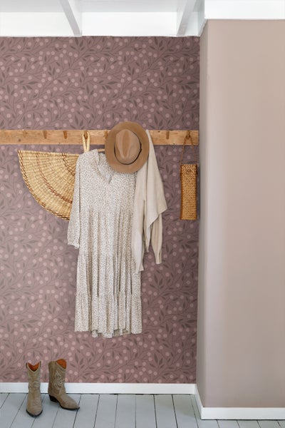 Zimmer mit Holzbett und mit Blättern und Beeren gemusterter Tapete