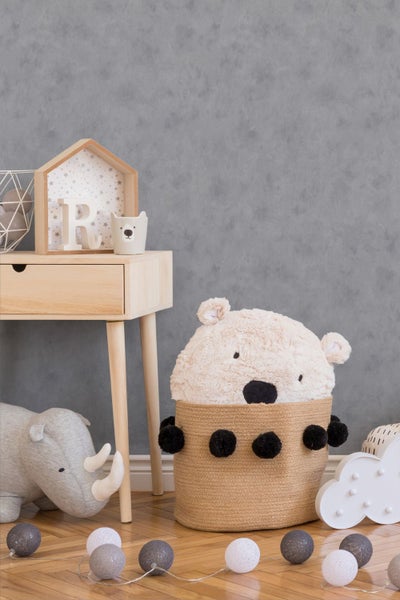 Kinderzimmer-Szene mit Holztisch, Bärenkorb, Spielzeug-Nashorn, Wolkenlampe und Lichterkette