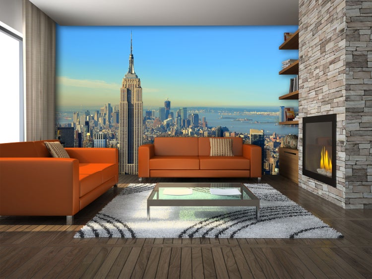 Wohnzimmer mit orangefarbenen Sofas, Couchtisch und Fototapete mit New York Skyline