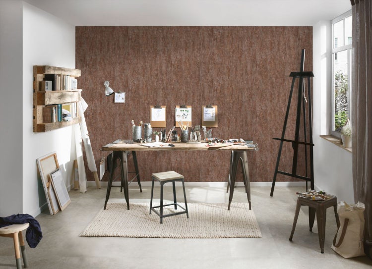 Künstleratelier mit Staffelei, Tisch und Regal an einer Wand mit Holzoptik-Tapete