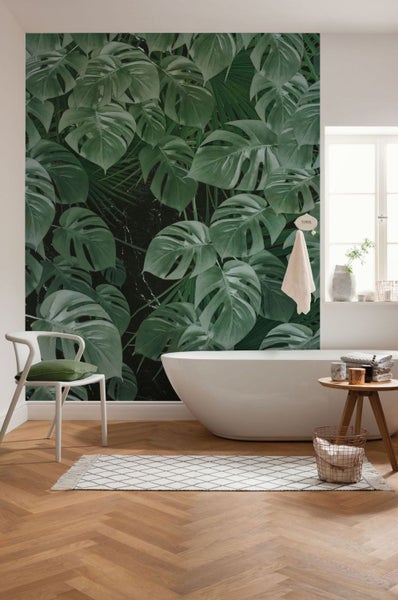 Badezimmer mit Monstera-Tapete, Badewanne und Holzboden