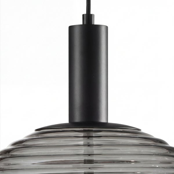 Nahaufnahme einer Pendelleuchte mit schwarzer Metallfassung und geriffeltem, rauchgrauem Glasschirm.