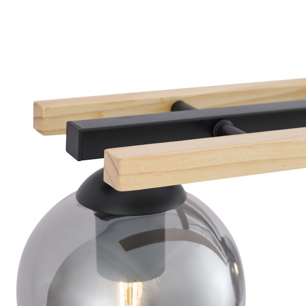 Detailansicht einer Hängeleuchte aus Holz und Metall mit einer runden Glaskugel und Leuchtmittel.