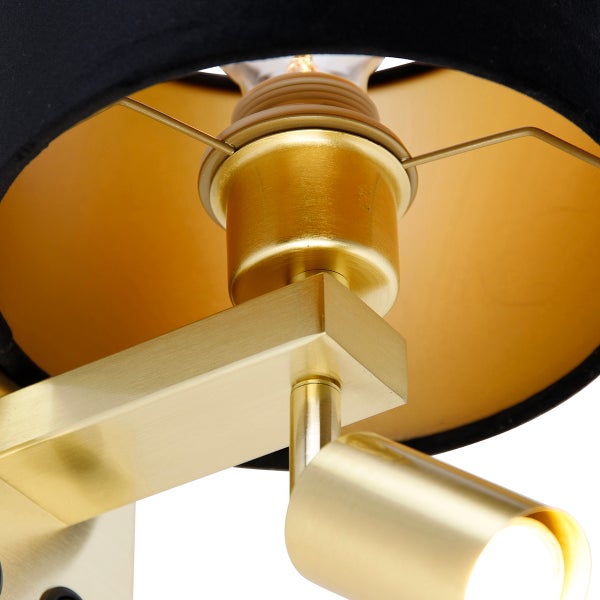 Detailansicht einer Lampe mit schwarzem Lampenschirm und goldenem Gestell