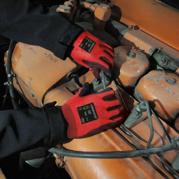 Person mit Arbeitshandschuhen von Leibwaechter bei der Reparatur an einem Motorblock.