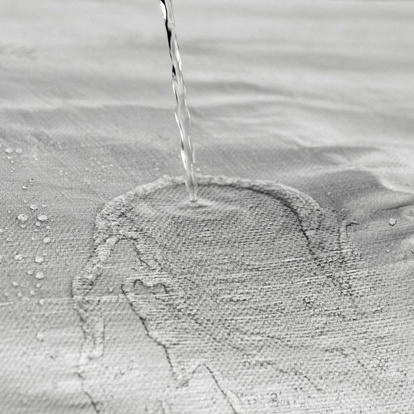 Wasser perlt auf einer wasserabweisenden Textilie ab.