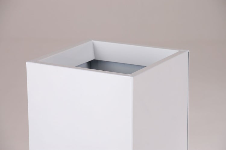 Detailansicht der oberen Ecke eines quadratischen, weißen Pflanzgefäßes aus Metall.