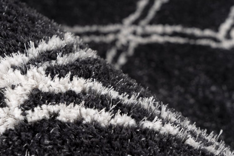 Detailansicht eines Hochflor-Teppichs mit geometrischem Muster.