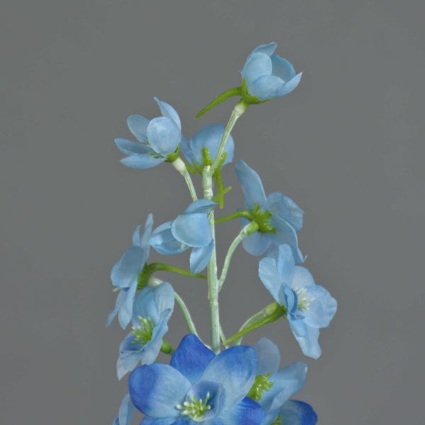 Künstlicher Blumenstiel mit mehreren blauen Blüten aus Textil für die Dekoration.