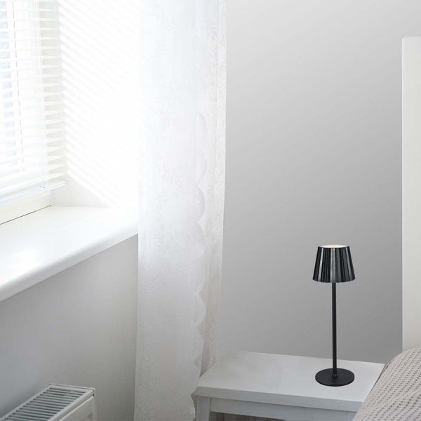 Schlafzimmer mit Nachttisch und darauf stehender Tischleuchte