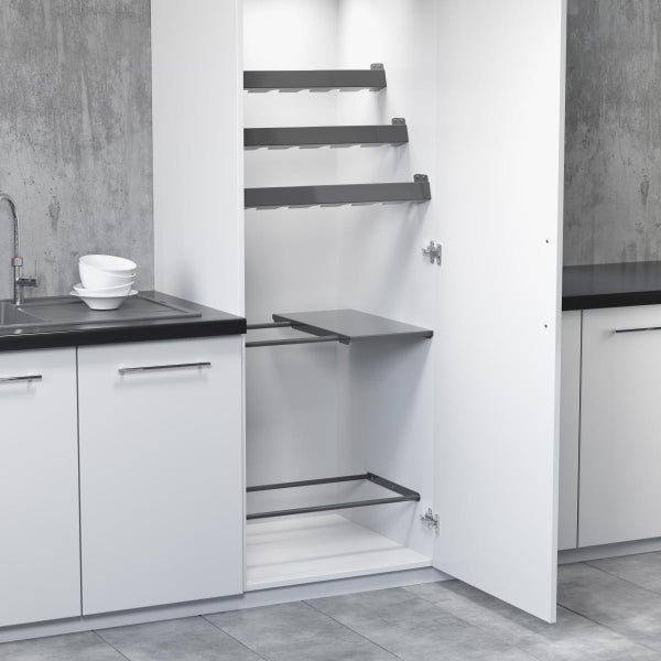 Offener weißer Hochschrank mit Besenhaltern und Ablagen in einer modernen Küche mit Betonoptik-Wand.