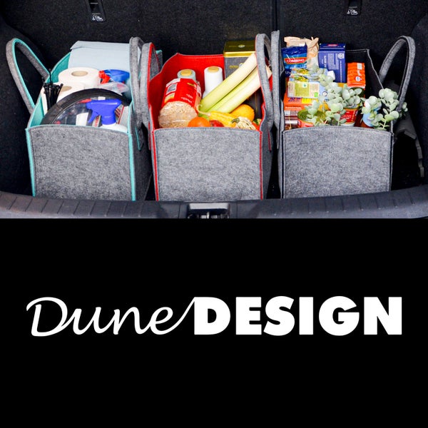 Drei graue Filztaschen mit farbigen Akzenten als Ordnungshelfer im Kofferraum gefüllt mit Lebensmitteln und Haushaltsartikeln, Dune Design Logo.