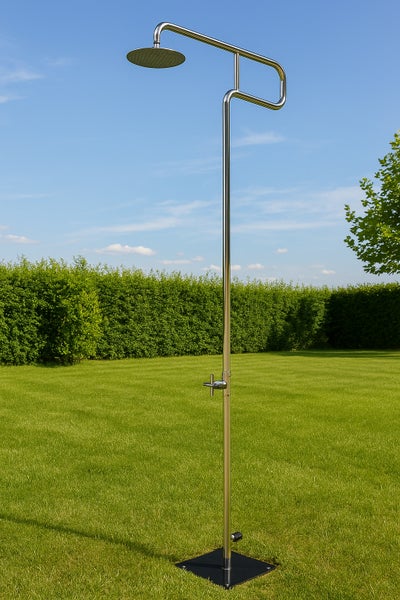 Freistehende Gartendusche aus Edelstahl mit großem runden Duschkopf und Bodenplatte auf einer Rasenfläche.