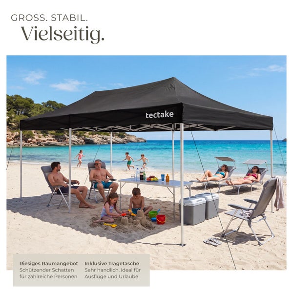 Schwarzes Faltpavillon von tectake mit Metallgestell auf einem Sandstrand, bietet Schatten für Personen mit Klappstühlen und Kühltaschen.