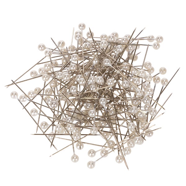 Ein Haufen von Stecknadeln mit runden Perlenköpfen aus Metall für Handarbeit und Schneiderarbeiten.