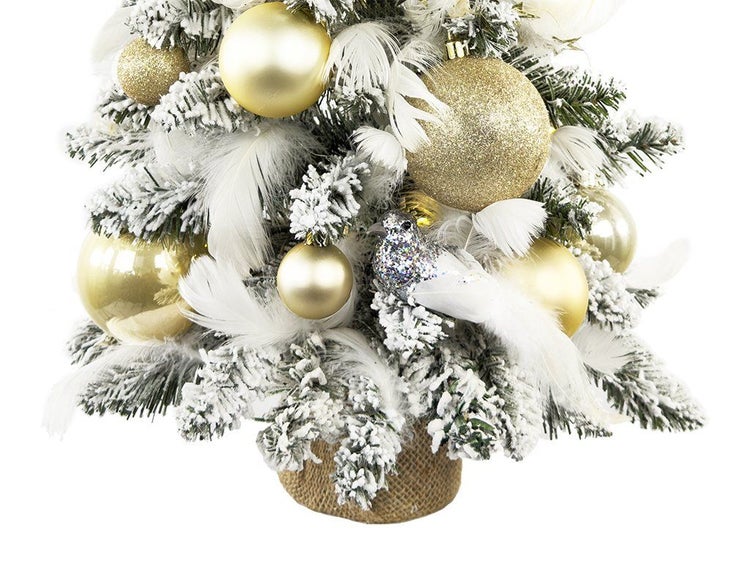 Künstlicher Weihnachtsbaum mit künstlichem Schnee dekoriert mit Weihnachtskugeln und Federn in Jutesack.