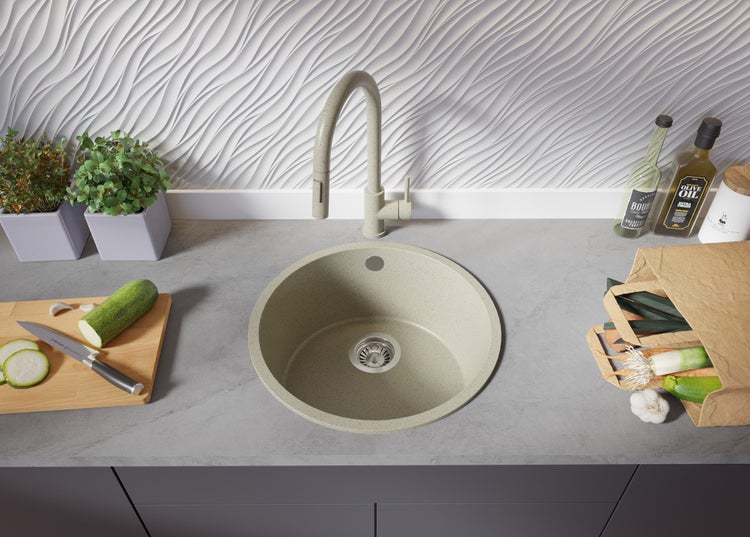 Küchenszene mit runder Spüle, Armatur, Gemüse und Küchenutensilien auf einer Arbeitsfläche