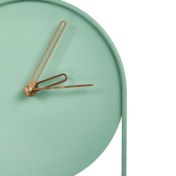 Detailansicht einer minimalistischen Tischuhr aus Metall mit goldenen Zeigern ohne Ziffern.