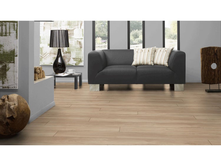 Laminatboden in heller Holzoptik in einem modernen Wohnzimmer mit dunklem Sofa und grauen Wänden.
