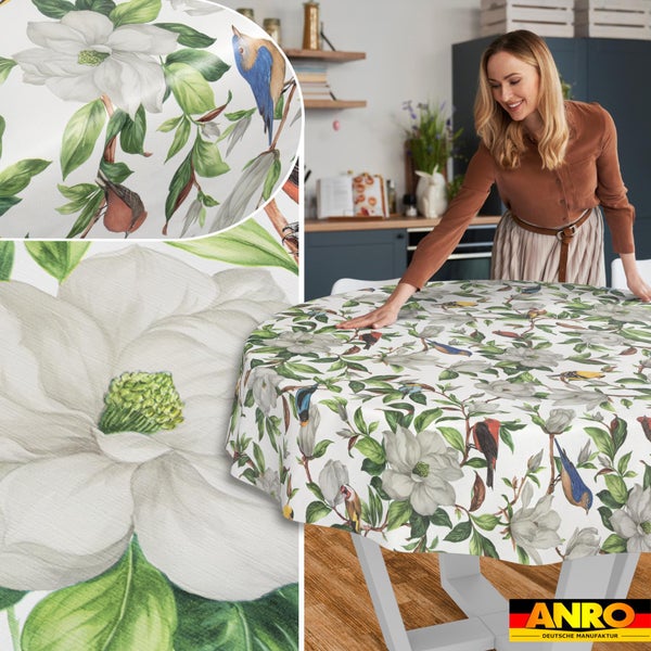 Runde Tischdecke mit einem Muster aus Magnolien und Vögeln auf einem Tisch in einer Küche, Detailansichten des Motivs und ANRO Logo.
