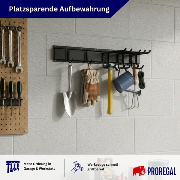 Wandmontierte Werkzeugleiste aus Metall mit Haken zur platzsparenden Aufbewahrung von Gartenwerkzeugen und Zubehör an einer hellen Steinmauer.