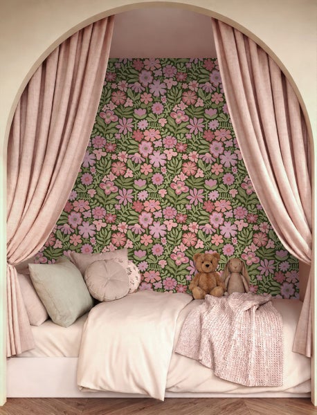 Gemütliches Kinderbett in einer hellen Bogennische mit Blumentapete, Stoffvorhängen, Zierkissen und Plüschtieren.