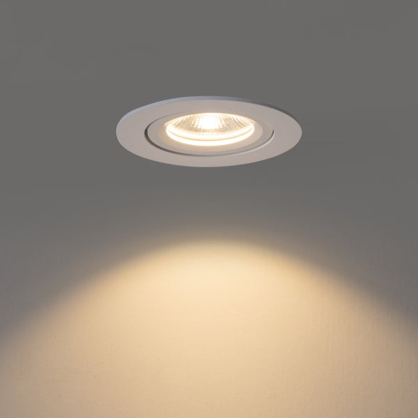 Runder LED-Einbaustrahler in Weiß mit eingeschaltetem Leuchtmittel und warmweißem Lichtkegel.