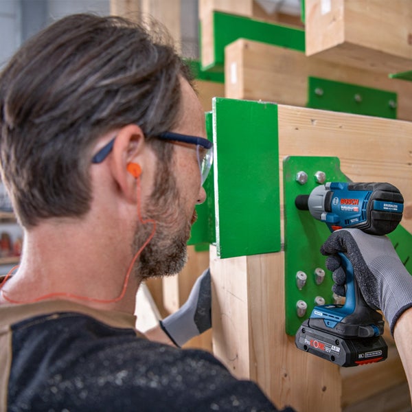 Handwerker mit Bosch Akku-Schlagschrauber beim Arbeiten an Holzkonstruktion