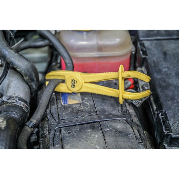 Gelbe Schlauchklemme von BGS technic an einem Autoschlauch